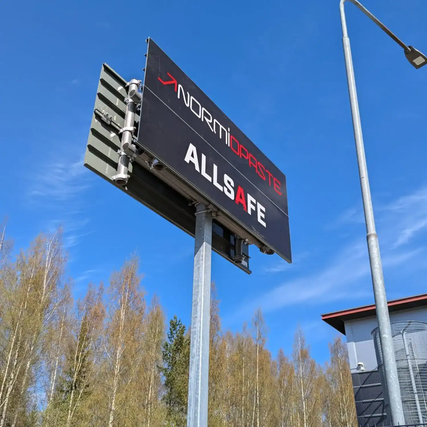 Normiprofiililla rakennettu opaste Normiopasteen pihassa
